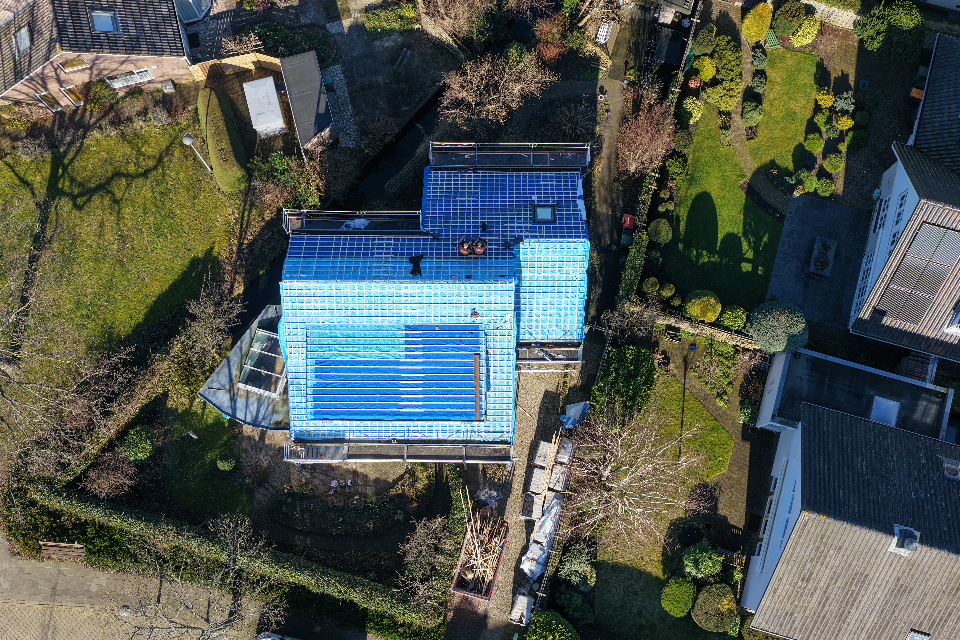 Dak tijdens renovatie met beschermende blauwe dakfolie in Warmond