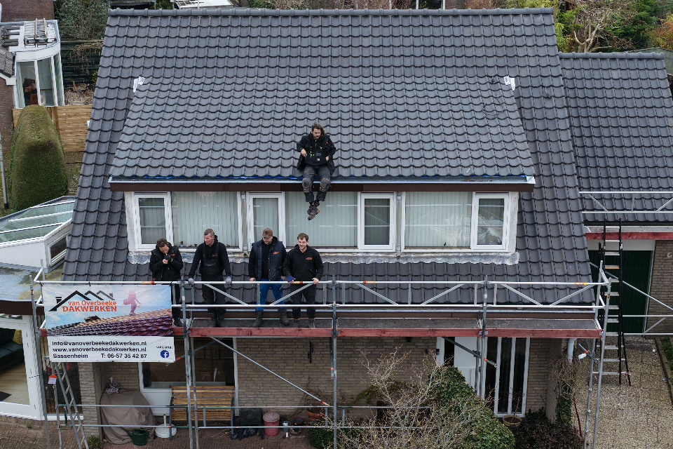 Dakdekkers poseren op een nieuw pannendak in Warmond