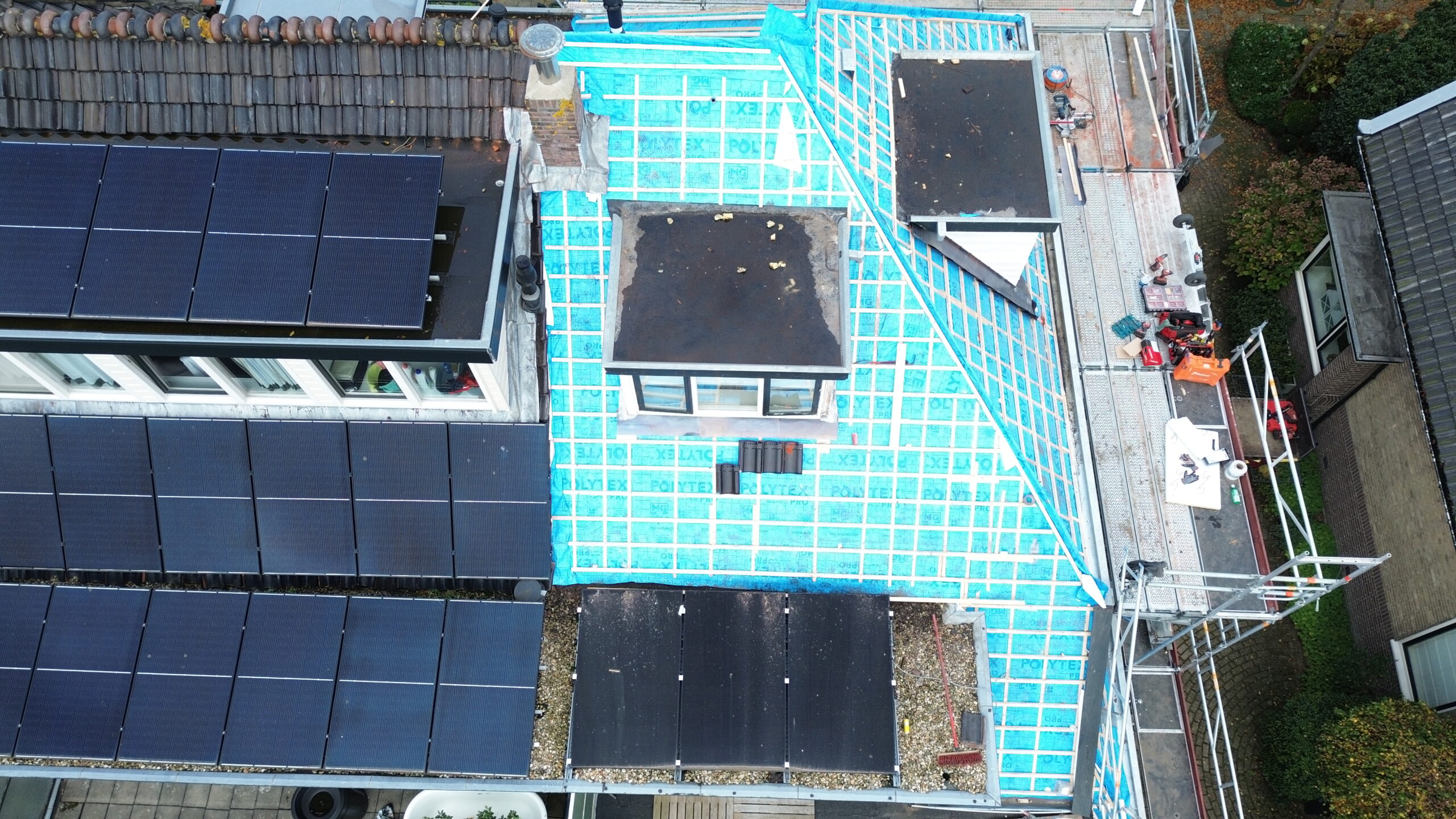 Woning tijdens dakrenovatie met blauwe dakfolie in Sassenheim