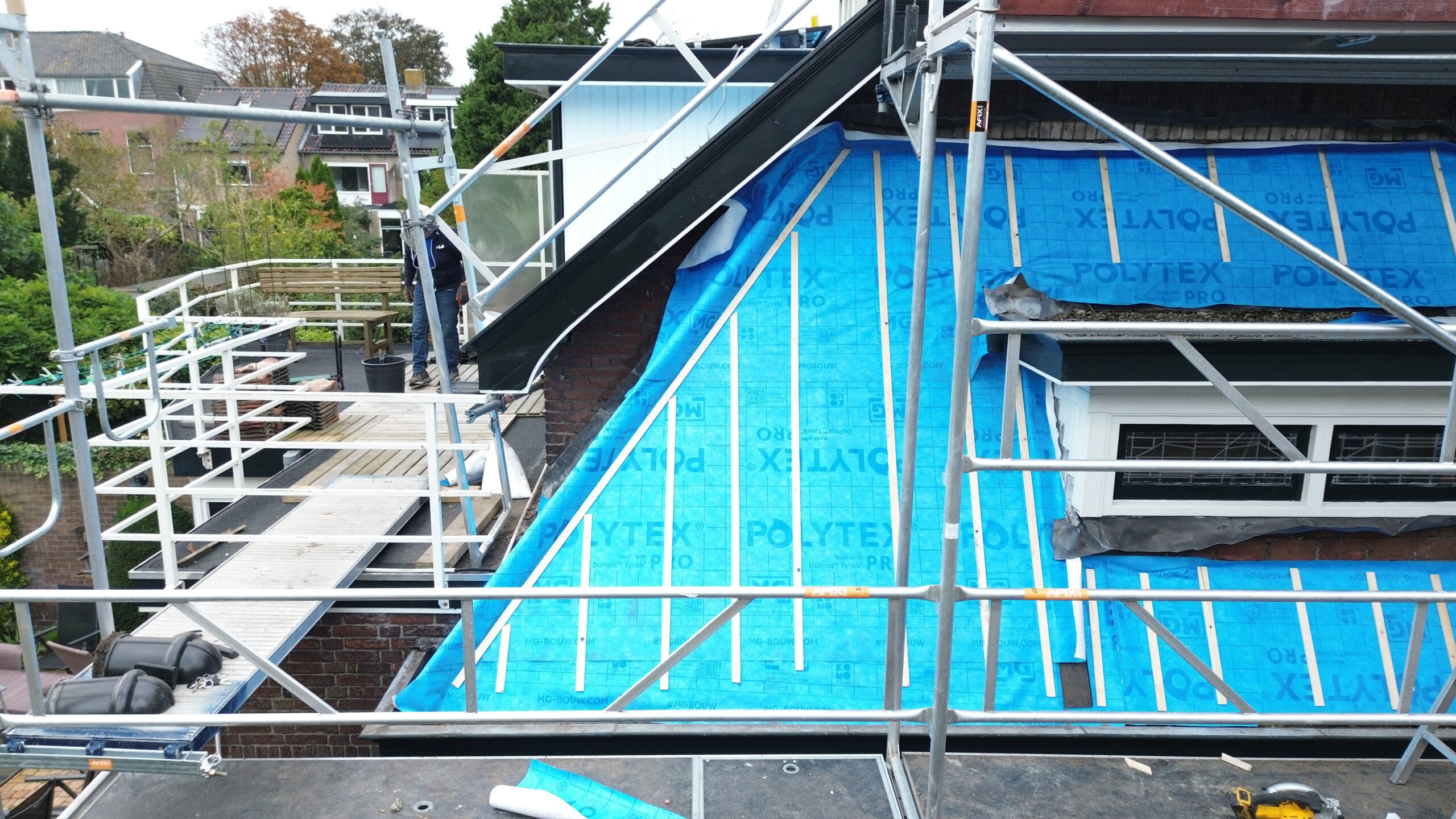 Dak van een woning tijdens renovatie met blauwe dakfolie in Sassenheim