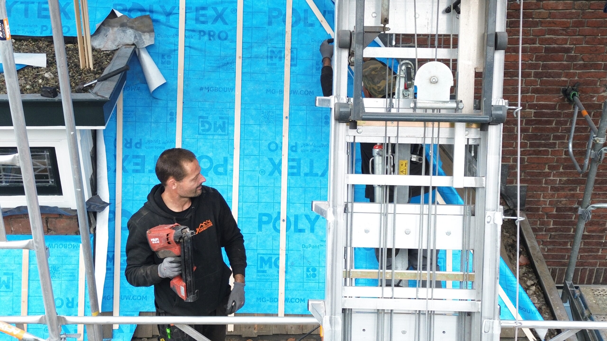 Dakdekker aan het werk bij een woning met steiger in Sassenheim